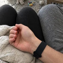 Leah B.'s photo: the band on her husband's wrist on the sofa, the baby's toys on the rug below.