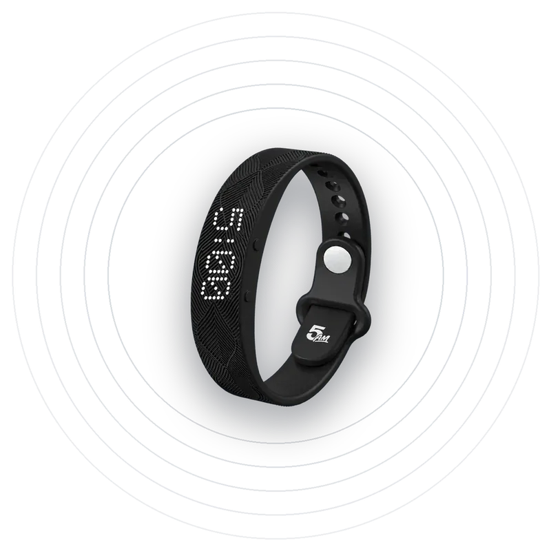 The Solo Wake Alarm band with its screen lit at 5:00, soft grey rings behind it.