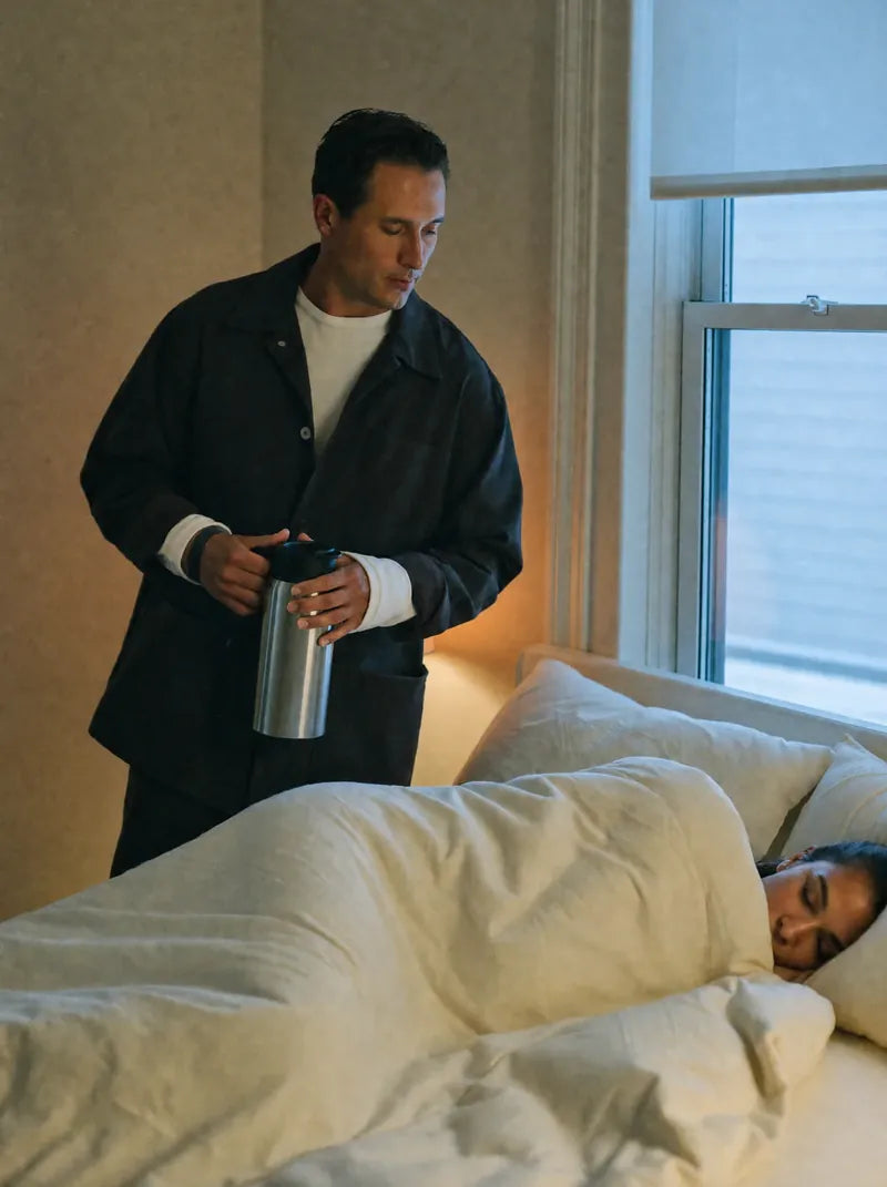 At 5:00 he stands by the bed dressed for work, thermos in hand, the 5AM band on his wrist; she sleeps on under the duvet
