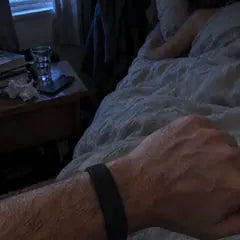 Chris T.'s photo: the band on his wrist at dawn, his wife still asleep in bed behind it.